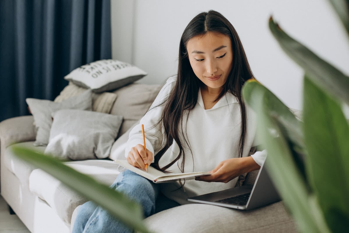 resized_asian-woman-studying-home-reading-sofa