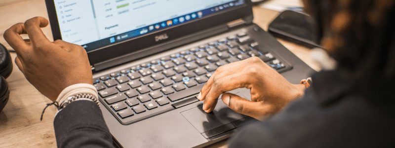 A person's hands working at a laptop computer, with one hand gesturing while the other uses the trackpad, representing a tenant researching and understanding their legal protections under the Renters' Rights Act for tenants to ensure they know their rights and responsibilities in the private rental sector.